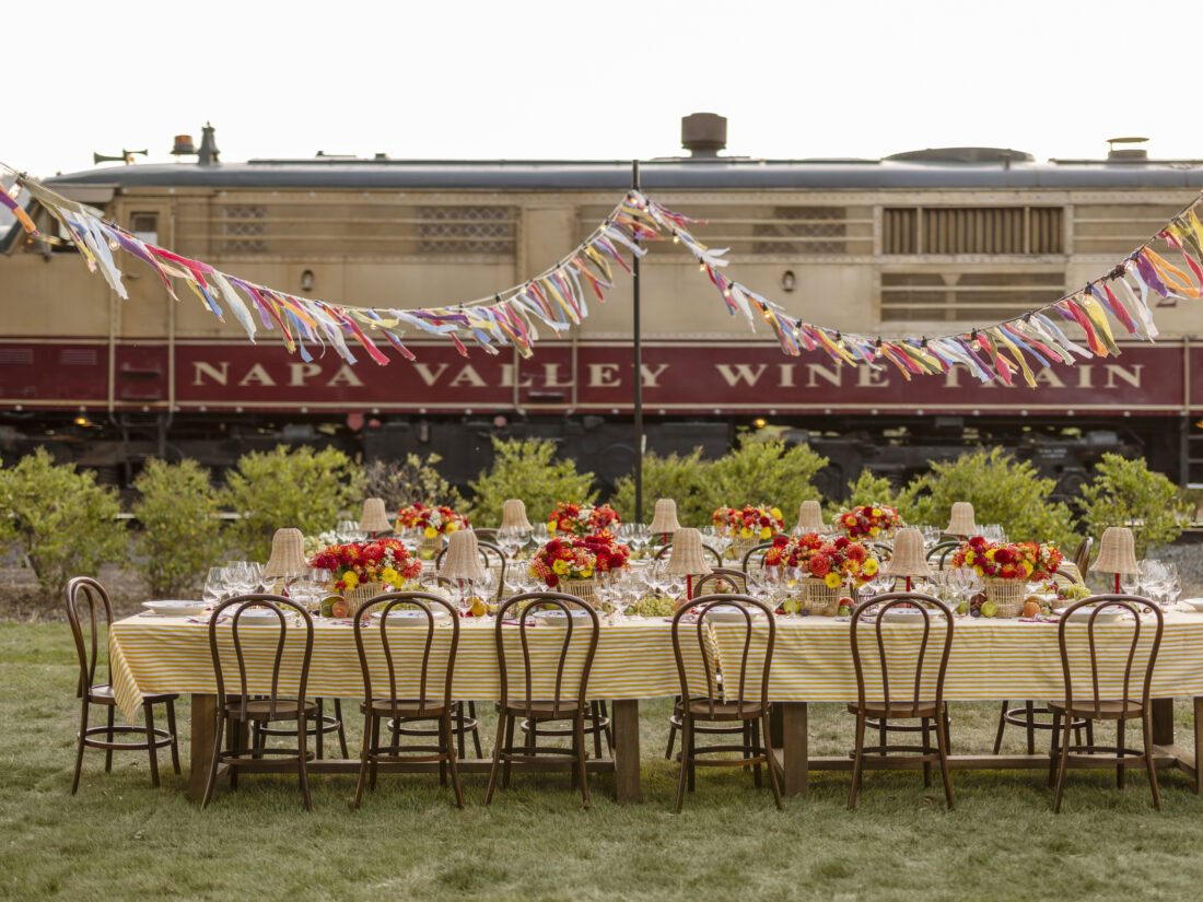 A set table outside with colorful bunting above it