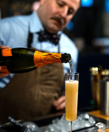 A man pours sparkling wine into a glass