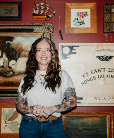 A portrait of a woman against a gallery wall