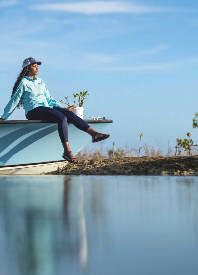 A woman sits on a boat above the water