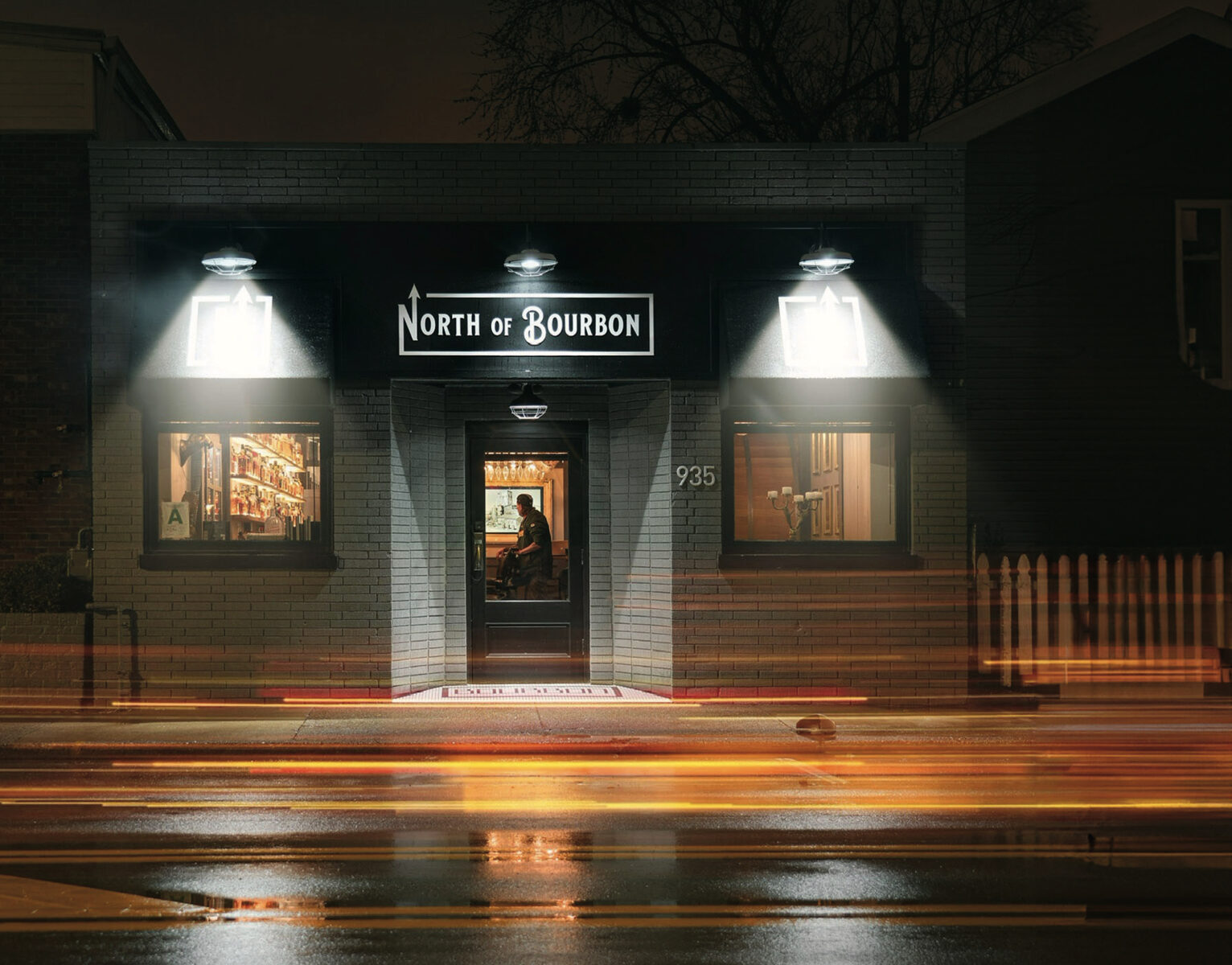Outside a restaurant at night with car lights in motion blur