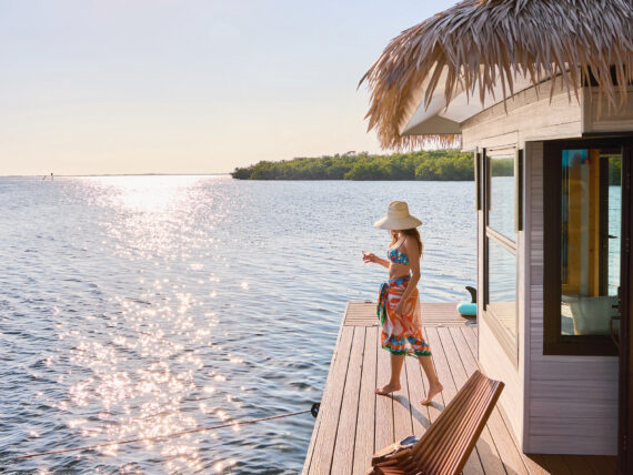 A woman stands on a floating dock on the water