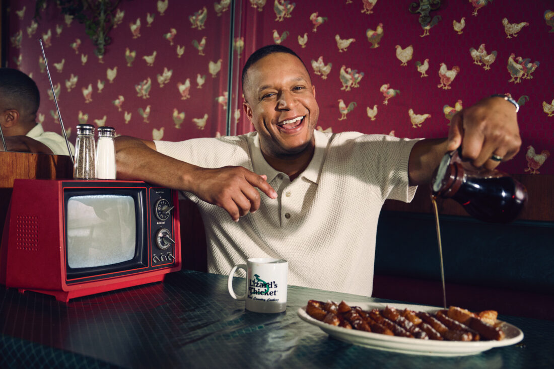Craig Melvin pours syrup over french toast in a restaurant