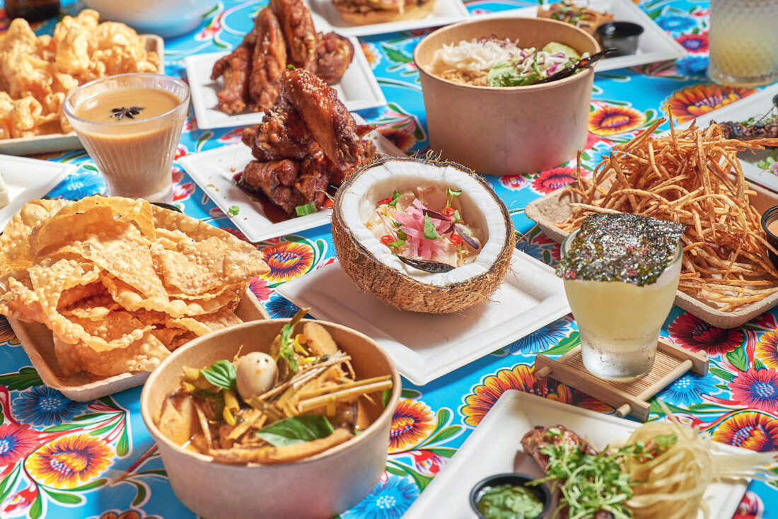 Coconut escolar ceviche, caramel fish sauce wings, and taro fries on a table
