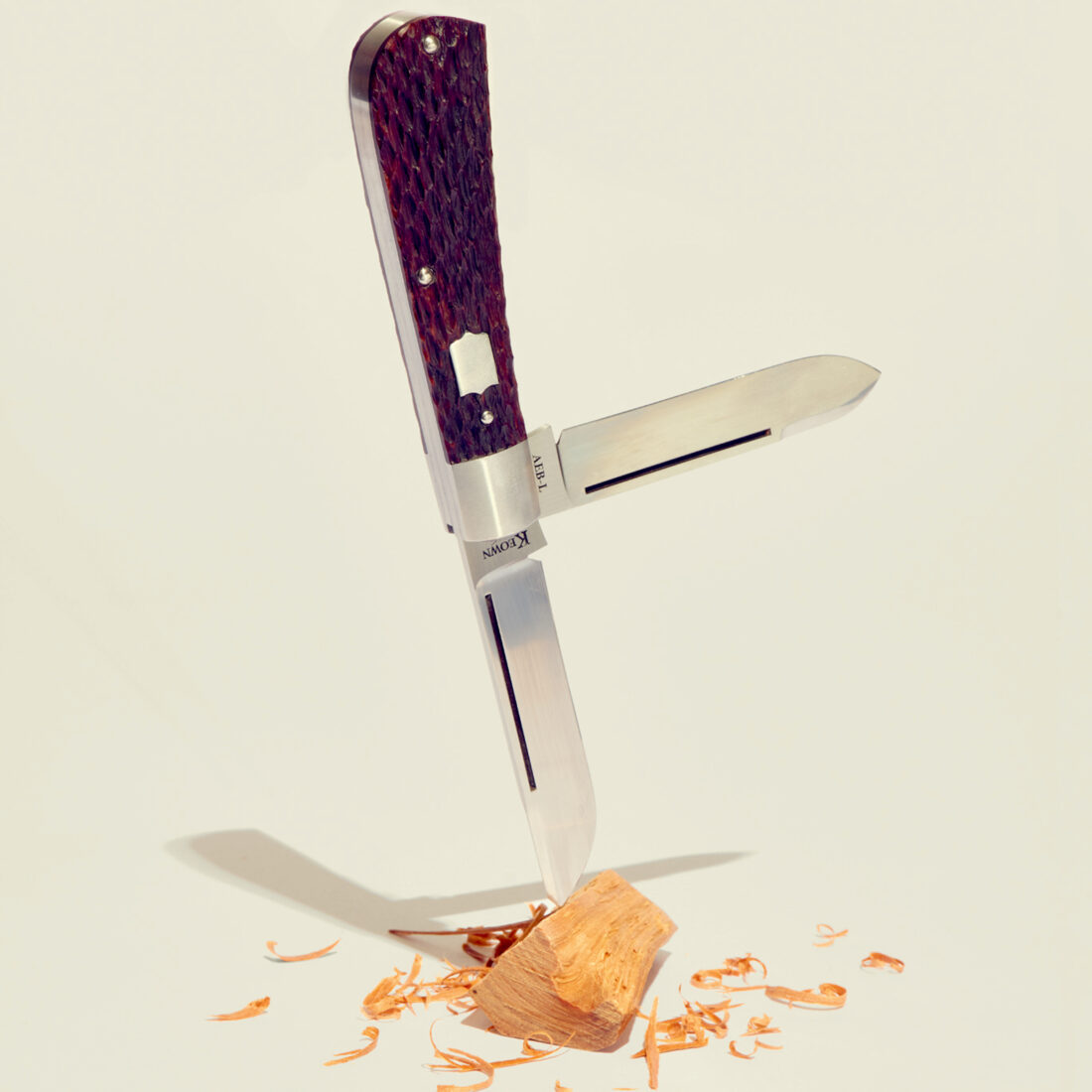 A pocket knife wedged in a piece of wood