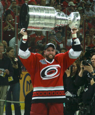 A man lifts a trophy into the air