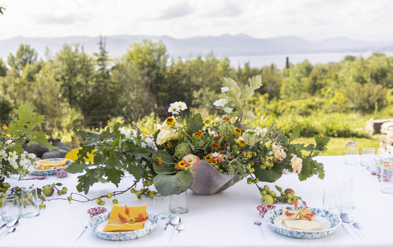 A table set with flowers and speckled enamelware