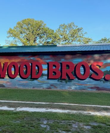 A painted side of a wood building that says "Wood Bros"