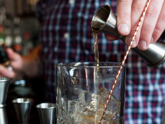 A bartender mixes bourbon