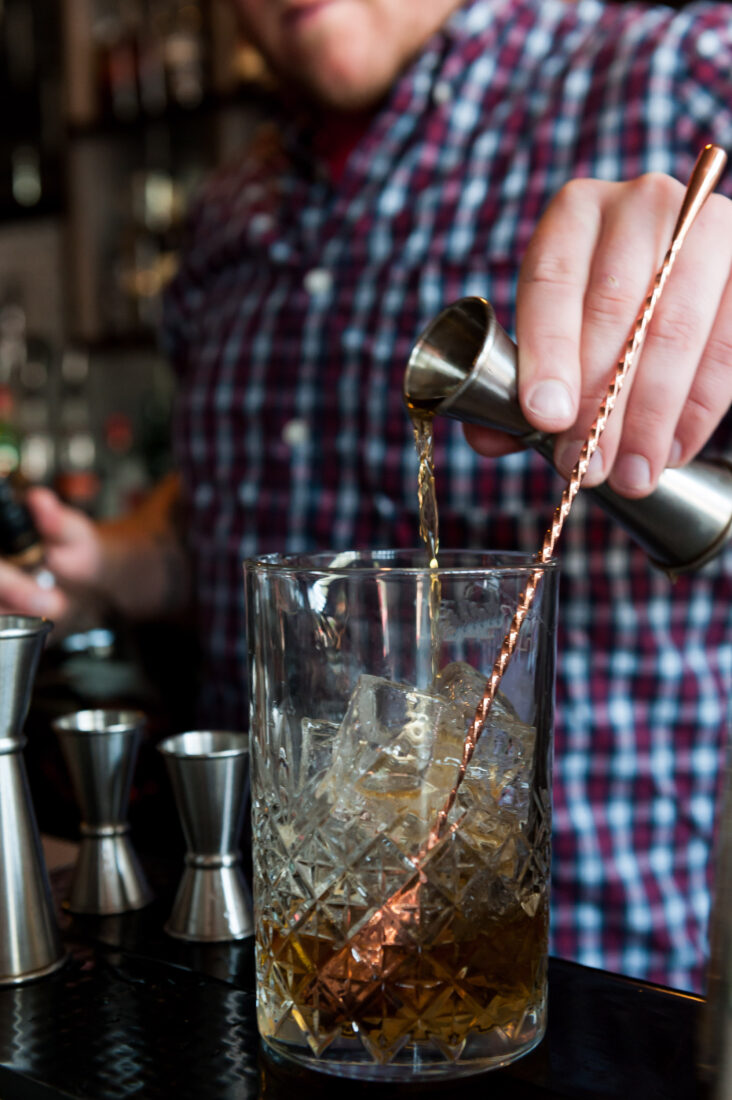 A bartender mixes bourbon