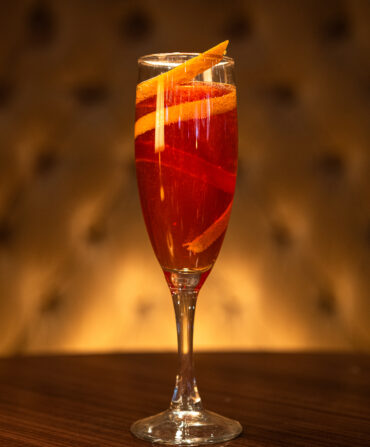 A cocktail in a tall flute glass