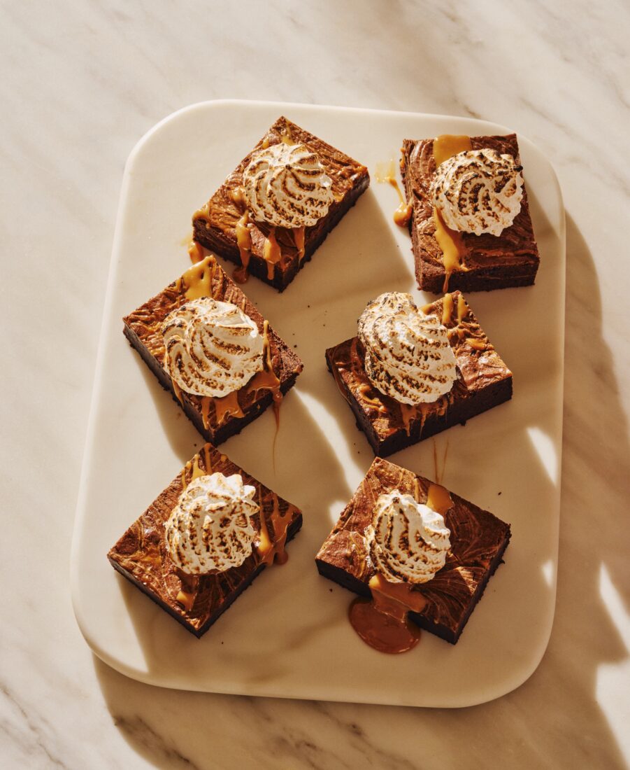 A plate of six brownies topped with toasted marshmallow fluff